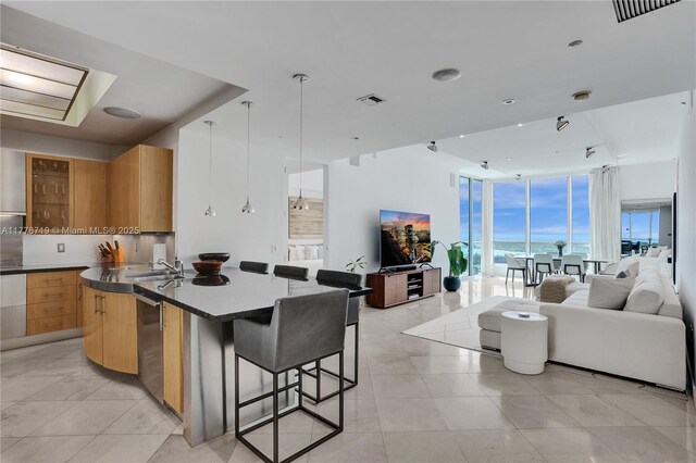 100 S Pointe Dr Unit 3102, Miami Beach, FL 33139 - kitchen with open floor plan, a wall of windows, modern cabinets, a breakfast bar, and a kitchen island with sink