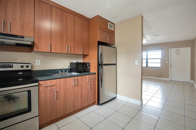 4061 N Dixie Hwy Unit 29, Oakland Park, FL 33334 - kitchen featuring under cabinet range hood, stainless steel appliances, a sink, dark countertops, and brown cabinets