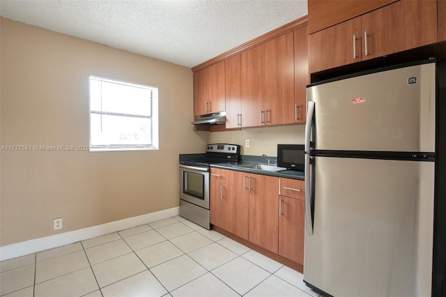 4061 N Dixie Hwy Unit 29, Oakland Park, FL 33334 - kitchen with appliances with stainless steel finishes, under cabinet range hood, dark countertops, brown cabinetry, and a textured ceiling