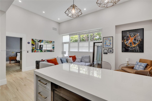 interior space featuring baseboards, a towering ceiling, visible vents, and recessed lighting