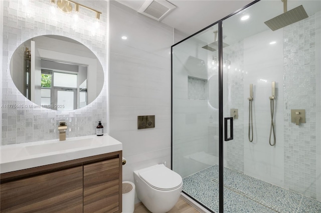 bathroom with tile walls, visible vents, toilet, and a stall shower