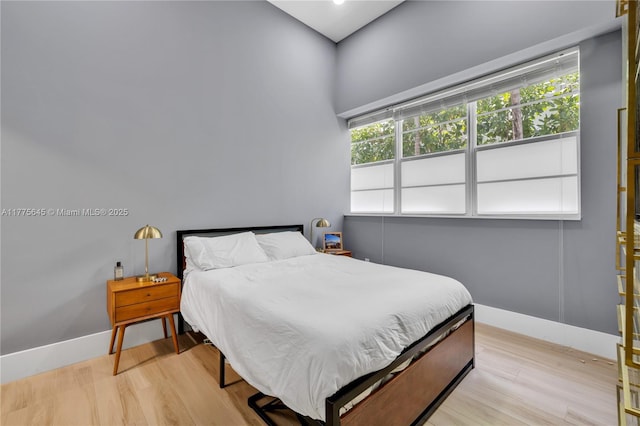 bedroom with recessed lighting, light wood-type flooring, and baseboards