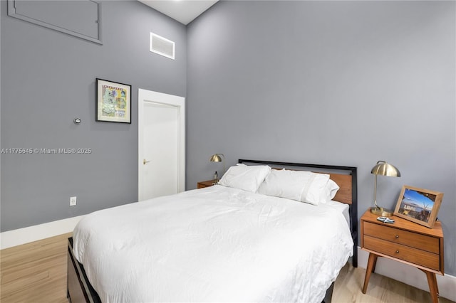 bedroom with baseboards, light wood-style flooring, and visible vents
