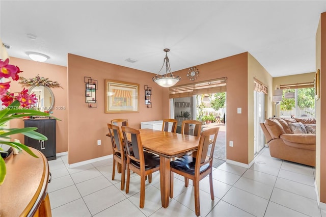 dining space with baseboards, visible vents, and light tile patterned floors