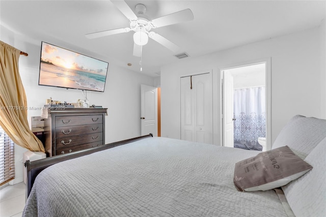 tiled bedroom featuring visible vents, a closet, ceiling fan, and ensuite bath