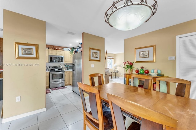 dining area with baseboards, visible vents, and light tile patterned floors