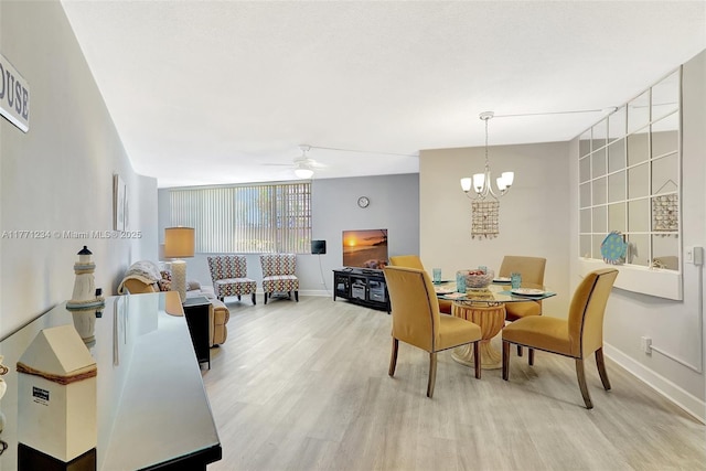 1936 S Ocean Dr Unit 2D, Hallandale Beach, FL 33009 - dining room with baseboards, light wood finished floors, ceiling fan, and a chandelier