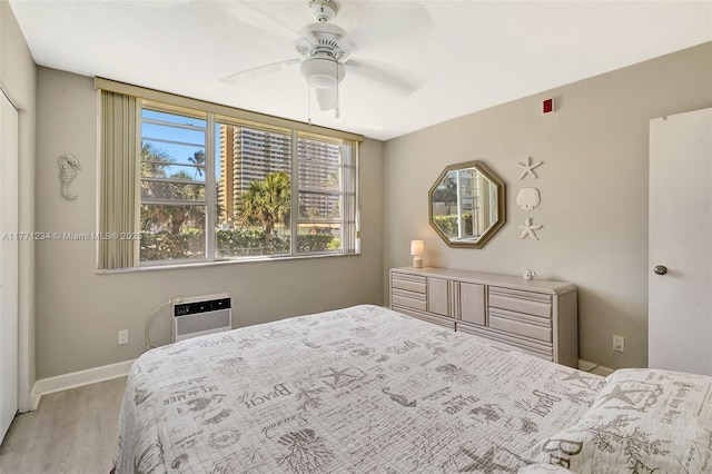 1936 S Ocean Dr Unit 2D, Hallandale Beach, FL 33009 - bedroom with wood finished floors, a wall unit AC, baseboards, and a ceiling fan