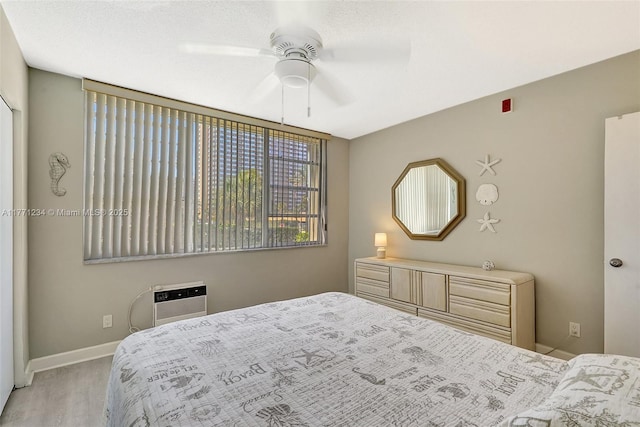 1936 S Ocean Dr Unit 2D, Hallandale Beach, FL 33009 - bedroom with wood finished floors, an AC wall unit, baseboards, and a ceiling fan