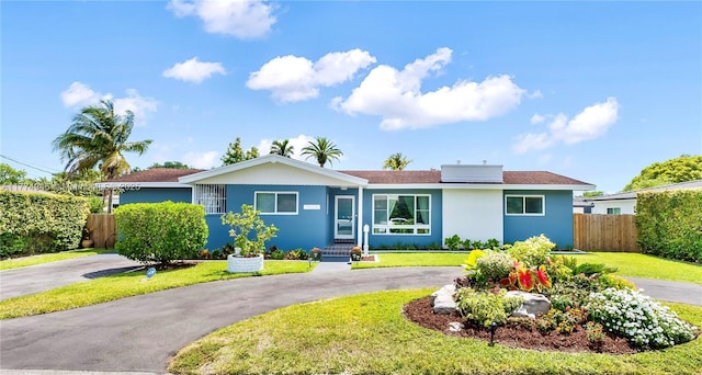 11215 NE 4th Ave, Miami, FL 33161 - ranch-style home with roof mounted solar panels, stucco siding, and curved driveway