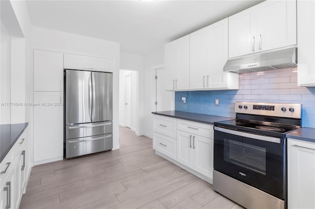 11215 NE 4th Ave, Miami, FL 33161 - kitchen featuring stainless steel appliances, under cabinet range hood, dark countertops, decorative backsplash, and white cabinets