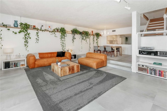 4901 SW 71st Pl Unit 4901, Miami, FL 33155 - living room with concrete flooring, a notable chandelier, a textured ceiling, and visible vents