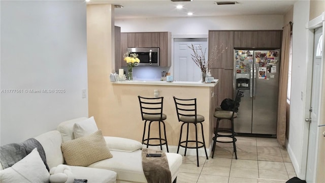 4441 SW 33rd Dr, West Park, FL 33023 - kitchen featuring stainless steel appliances, a kitchen breakfast bar, a peninsula, modern cabinets, and light countertops
