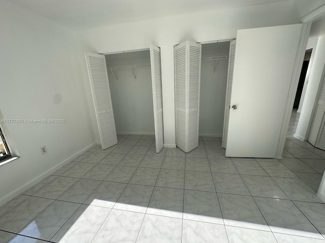 28315 SW 141st Pl Unit 28315, Homestead, FL 33033 - unfurnished bedroom featuring multiple closets, baseboards, and light tile patterned floors