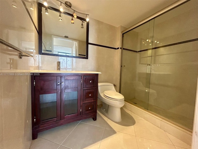 bathroom with toilet, vanity, a stall shower, and tile patterned floors