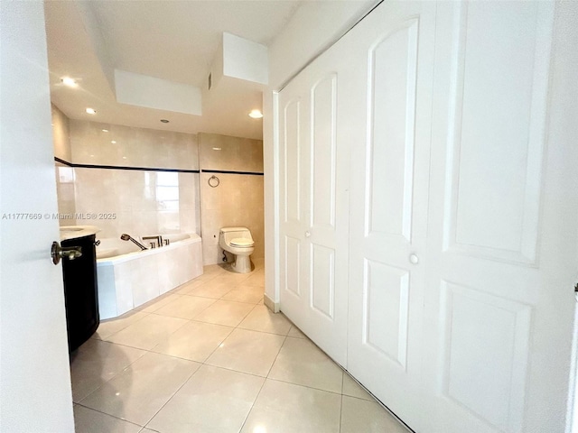 bathroom with tile patterned floors, toilet, and a bath