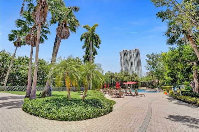 surrounding community featuring a swimming pool, fence, and a patio