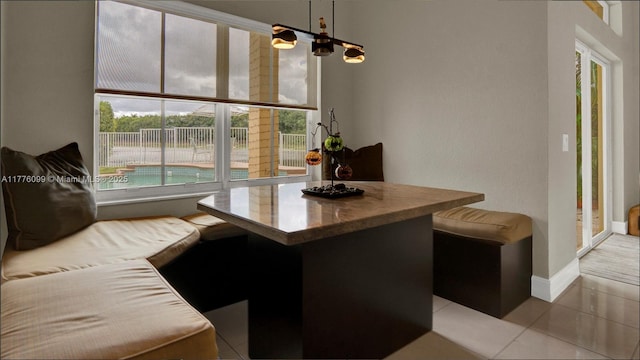 dining room featuring a chandelier, tile patterned flooring, and baseboards