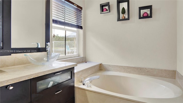 bathroom featuring a garden tub and vanity
