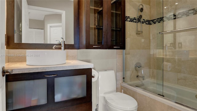 bathroom with tiled shower / bath combo, toilet, and vanity