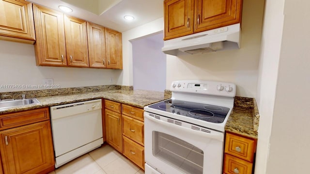 kitchen featuring light tile patterned floors, under cabinet range hood, recessed lighting, white appliances, and brown cabinetry