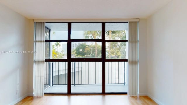 entryway with a healthy amount of sunlight, light wood-style flooring, and baseboards
