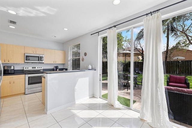 1431 SE 18th Ter, Homestead, FL 33035 - kitchen featuring light brown cabinetry, appliances with stainless steel finishes, dark countertops, light tile patterned floors, and visible vents