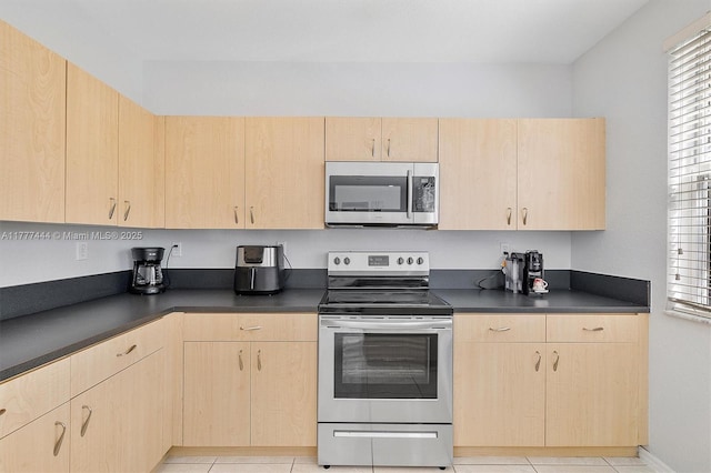 1431 SE 18th Ter, Homestead, FL 33035 - kitchen featuring light brown cabinets, dark countertops, light tile patterned flooring, and stainless steel appliances