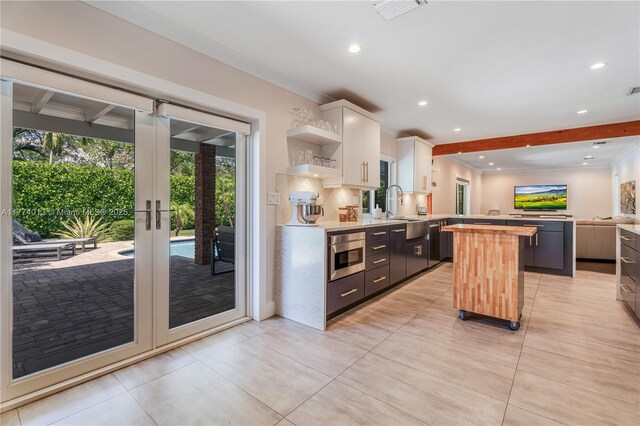 7465 SW 159th Ter, Palmetto Bay, FL 33157 - kitchen featuring decorative backsplash, oven, a kitchen island, white cabinetry, and open shelves