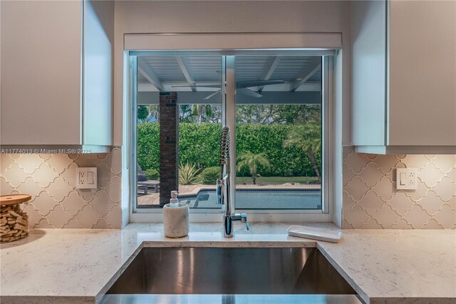 7465 SW 159th Ter, Palmetto Bay, FL 33157 - kitchen with tasteful backsplash, light stone countertops, and a sink