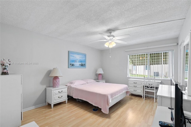 336 Pine Ridge Cir Unit B-1, Green Acres, FL 33463 - bedroom with light wood-style floors, ceiling fan, baseboards, and a textured ceiling