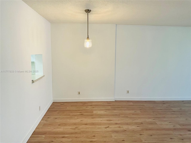 unfurnished dining area with light wood-style floors and baseboards