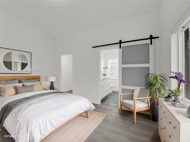 17663 SW 5th St, Pembroke Pines, FL 33029 - bedroom with connected bathroom, a barn door, and light wood finished floors