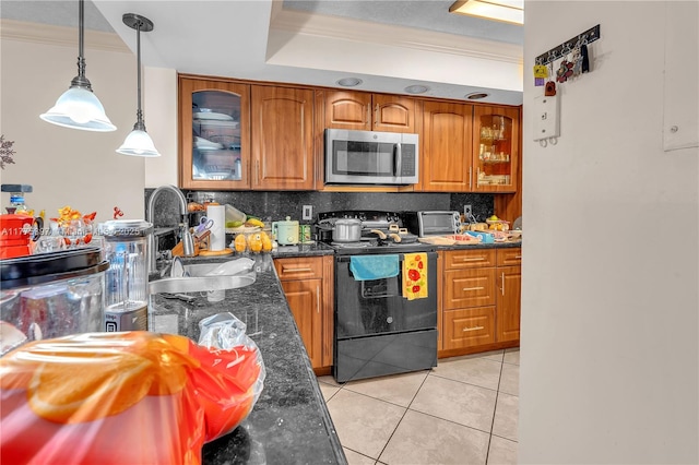 18840 NW 57th Ave Unit 107, Hialeah, FL 33015 - kitchen with a sink, black range with electric stovetop, brown cabinets, stainless steel microwave, and decorative backsplash
