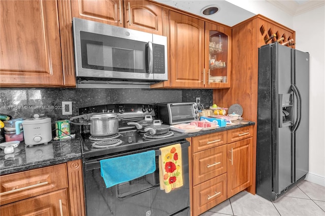 18840 NW 57th Ave Unit 107, Hialeah, FL 33015 - kitchen with decorative backsplash, light tile patterned flooring, black appliances, and brown cabinets