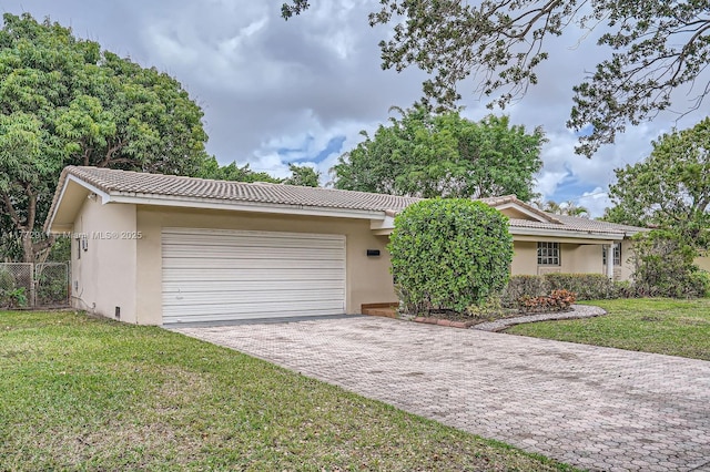 ranch-style home with a tile roof, a garage, stucco siding, and a front lawn