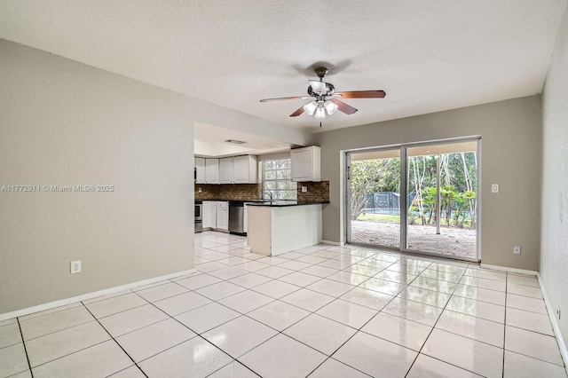 unfurnished living room with light tile patterned floors, baseboards, a ceiling fan, and a textured ceiling