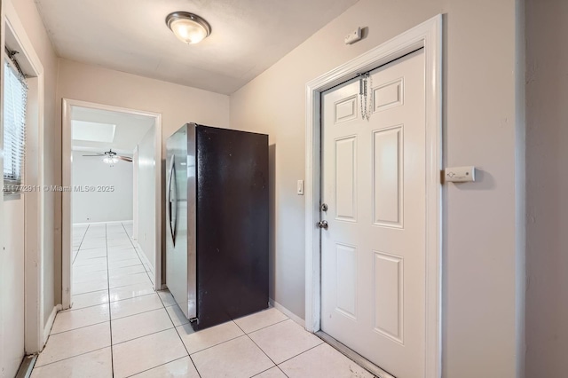 hallway featuring baseboards and light tile patterned flooring
