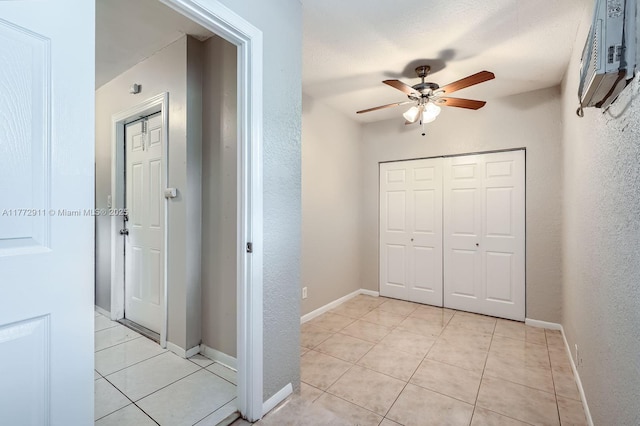 hallway with a wall mounted AC, light tile patterned flooring, and baseboards