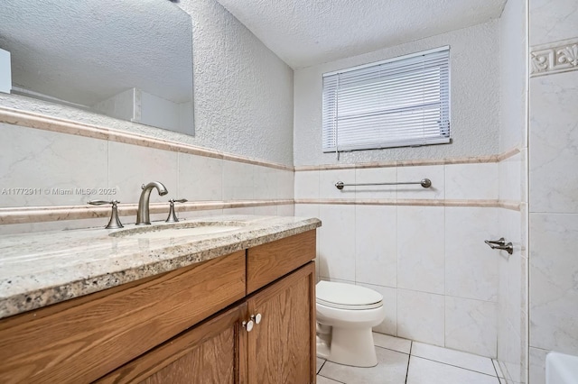 full bathroom featuring a textured ceiling, tile patterned flooring, toilet, tile walls, and a textured wall