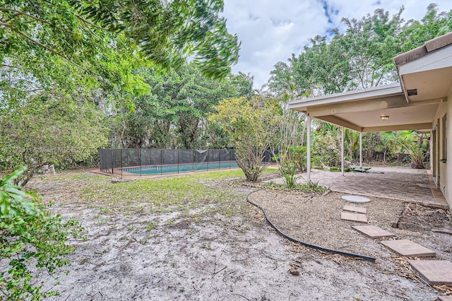view of yard with a patio area, fence, and a fenced in pool