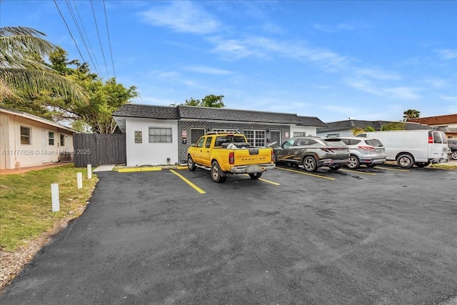 uncovered parking lot featuring fence