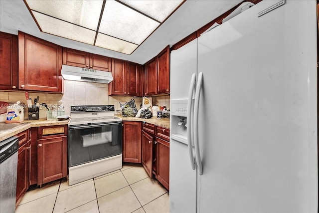 kitchen featuring light tile patterned flooring, decorative backsplash, light countertops, white appliances, and under cabinet range hood