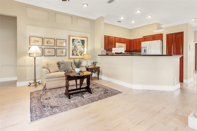 living area with crown molding, visible vents, baseboards, and light wood-style flooring