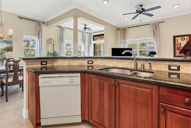 kitchen with dishwasher, a sink, ceiling fan, dark stone counters, and decorative backsplash