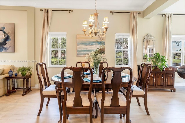 dining space featuring light wood-style flooring, an inviting chandelier, and ornamental molding