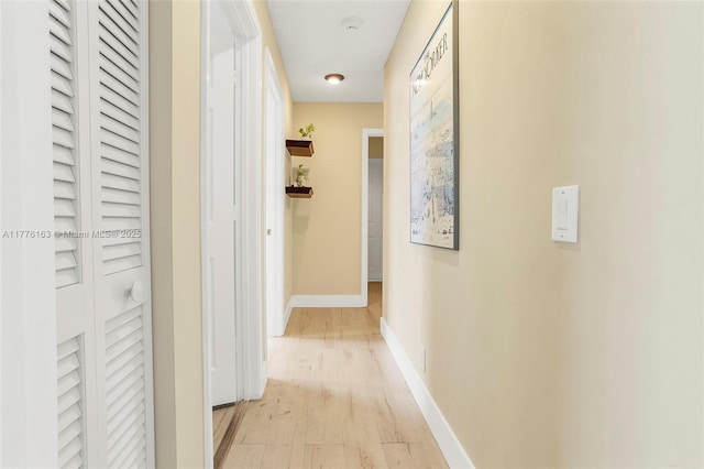 hallway with light wood-style floors and baseboards