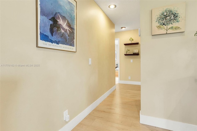 corridor featuring light wood-style floors, baseboards, and recessed lighting