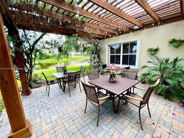 view of patio featuring outdoor dining space, a pergola, and a water view