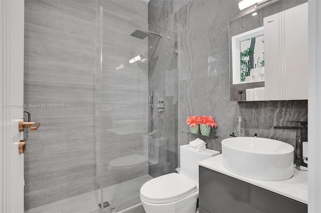 full bath featuring vanity, toilet, tasteful backsplash, and a stall shower